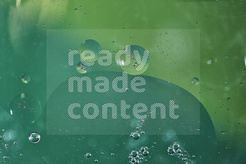 Close-ups of abstract oil bubbles on water surface in shades of green