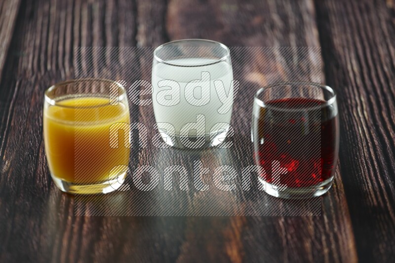 Cold drinks in a glass cup such as water, tamarind, qamar eldin, sobia, milk and hibiscus on wooden background