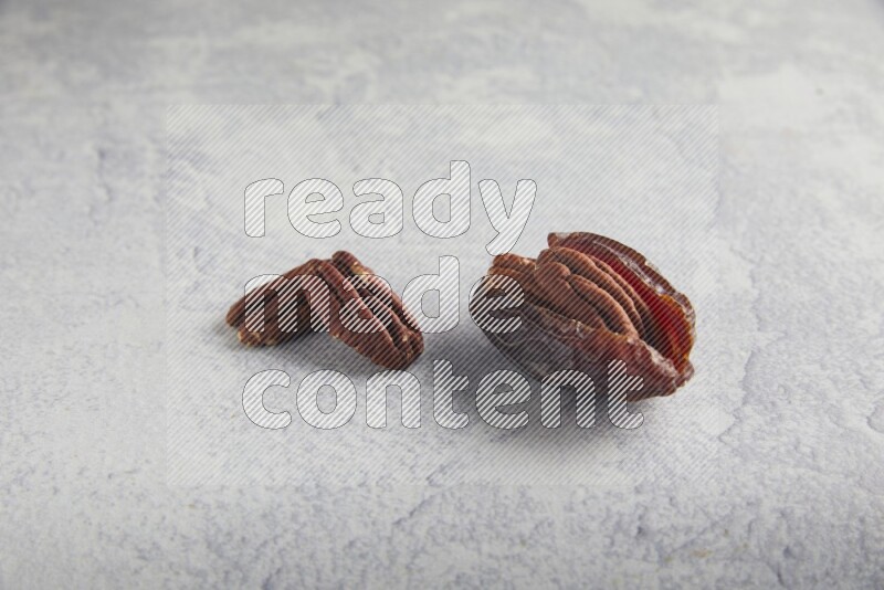 pecan stuffed madjoul date on a light grey background