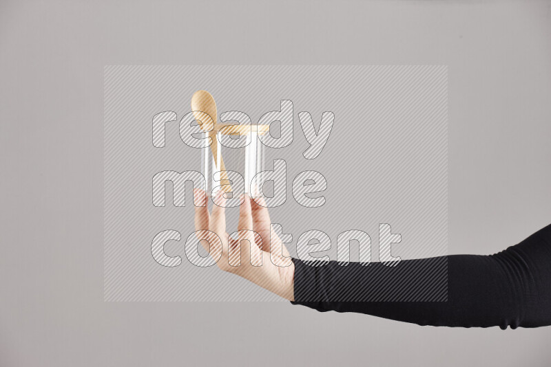 امرأة ترتدي عباءة سوداء تحمل أدوات زجاجية مختلفة في أوضاع متعددة