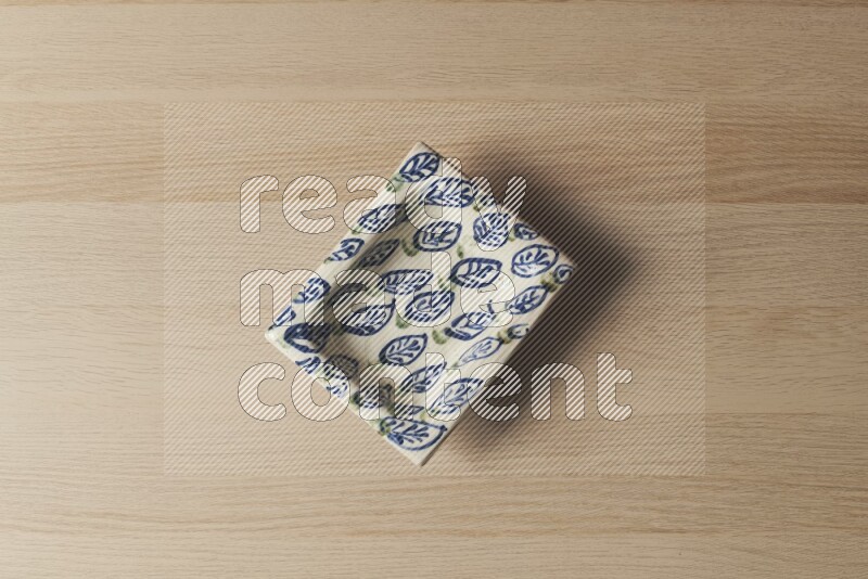 A decorative pottery plate on light wooden background
