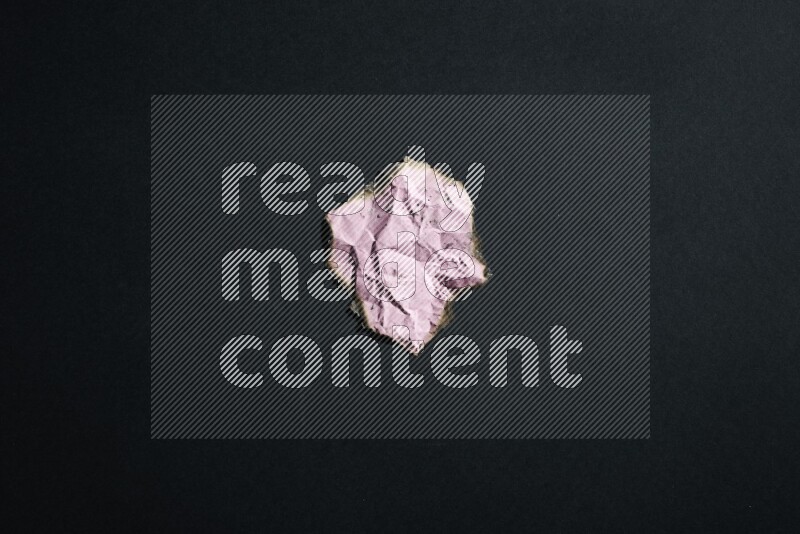 Burnt multicolored paper on black background