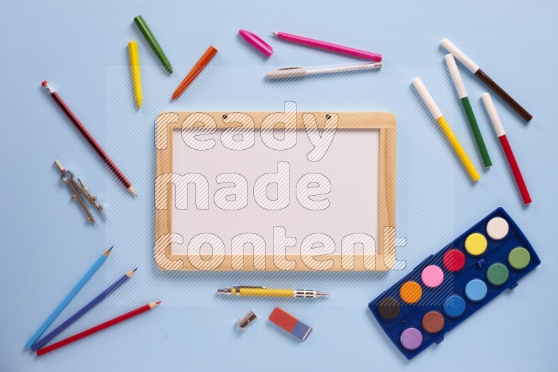 A whiteboard with assorted school supplies on blue background