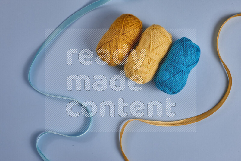 مجموعة من أدوات الخياطة والتفصيل صفراء وزرقاء اللون على خلفية زرقاء