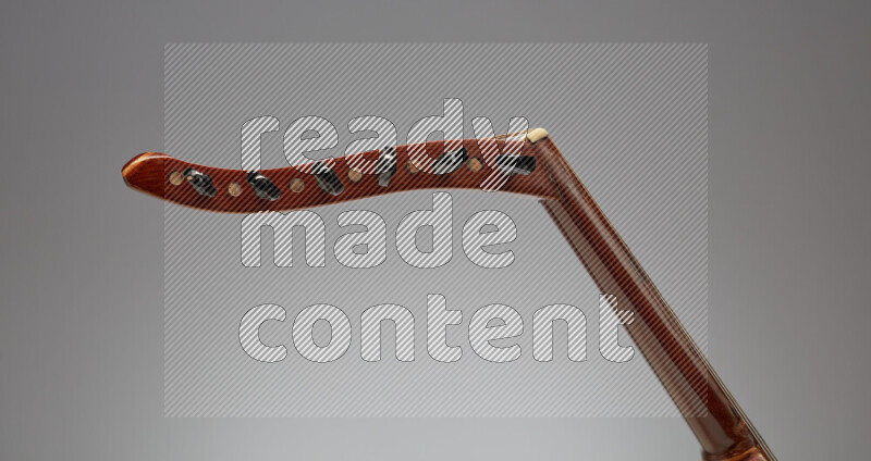 parts of a brown wooden Oud in a gray background