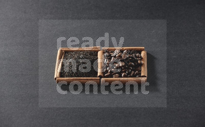 مربعان من أعواد القرفة ممتلئان بحبوب القهوة والشاي الأسود علي خلفية سوداء