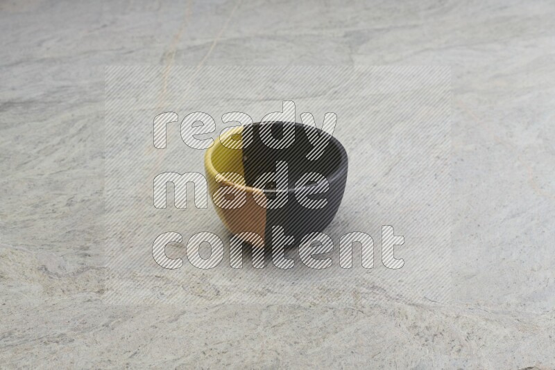 A multicolored pottery bowl on grey marble background