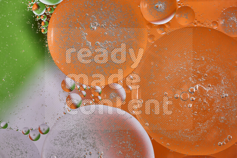 Close-ups of abstract oil bubbles on water surface in shades of orange, green and white