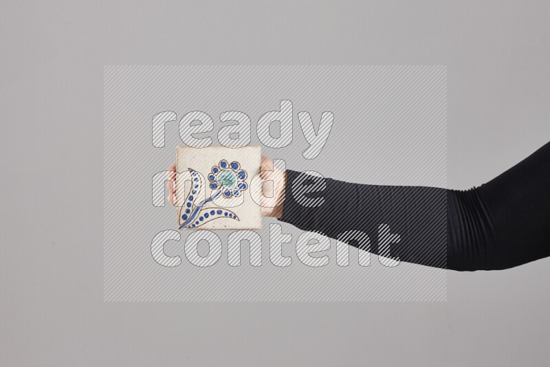 A woman in black abaya holding different pottery essentials in different positions