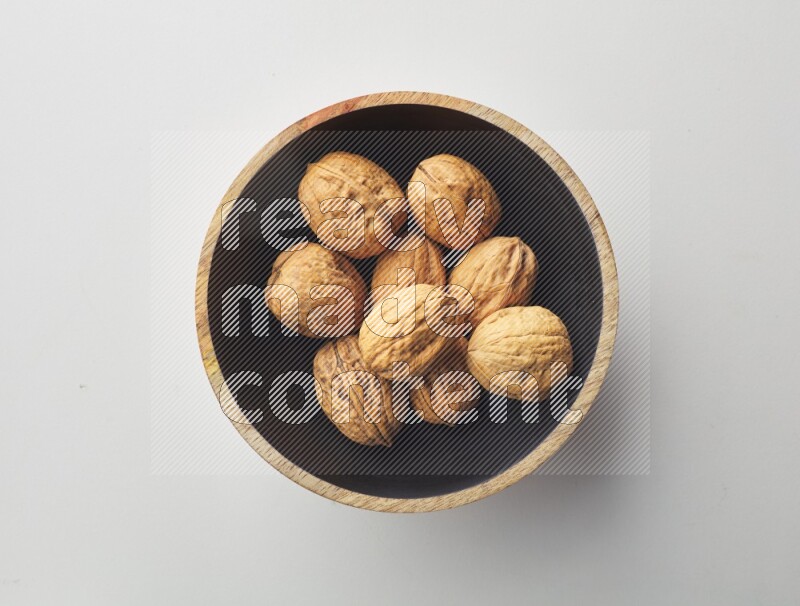 Top-view shot of walnut in a container on white background