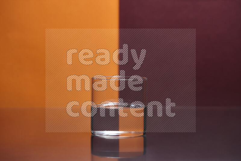 The image features a clear glassware filled with water, set against orange and dark red background