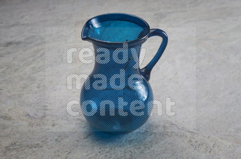 A colored glass jug on grey marble background