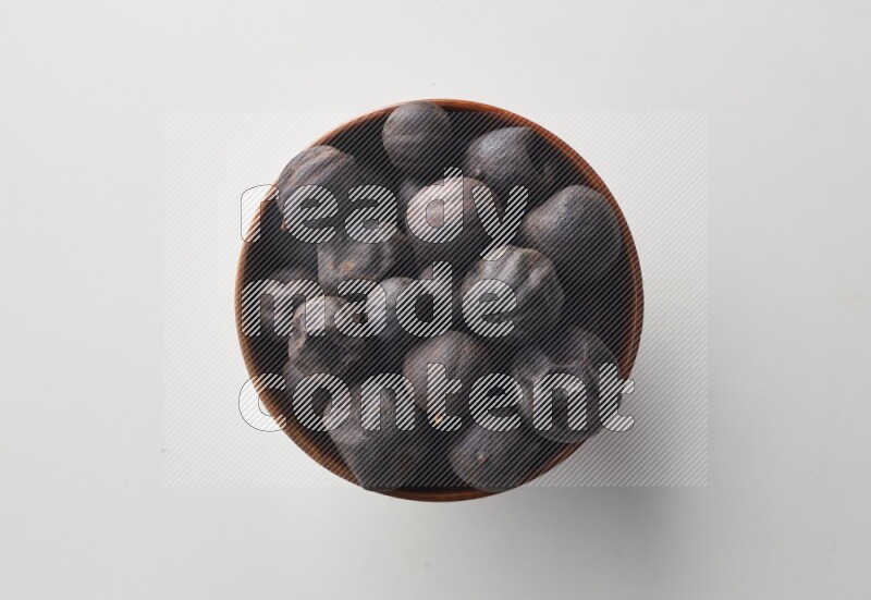 Top-view shot of dried lime (loomi) in a container on white background