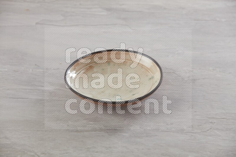 multi color ceramic round plate on grey textured countertop