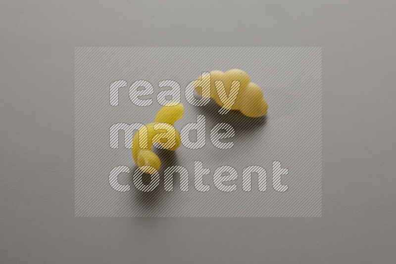 Twist pasta with other types of pasta on grey background
