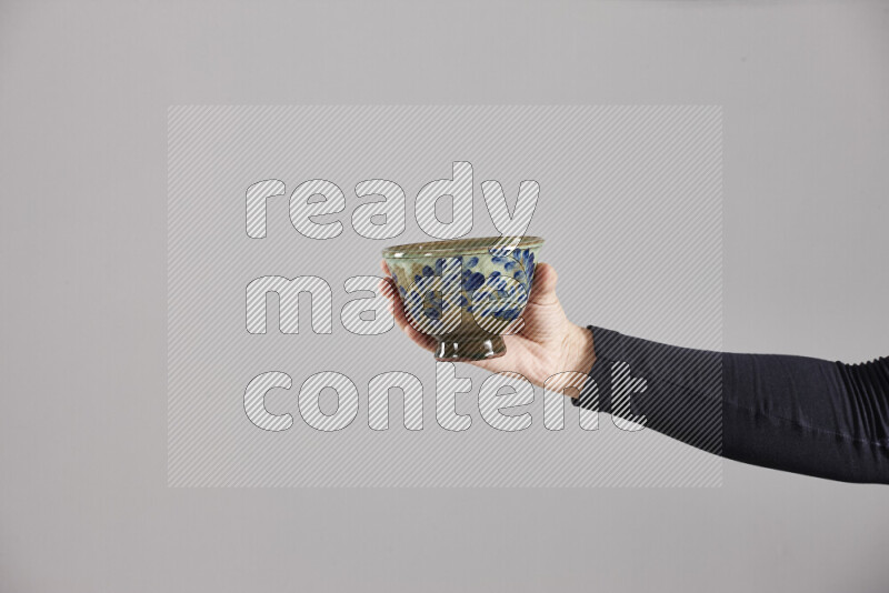 A woman in black abaya holding different pottery essentials in different positions