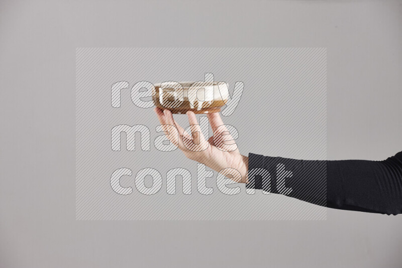 A woman in black abaya holding different pottery essentials in different positions
