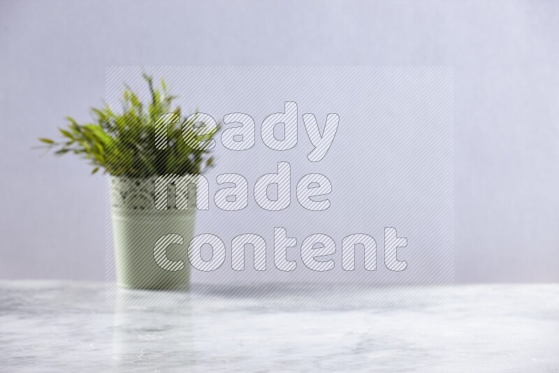 Artificial plant in green decorative pot on grey marble background