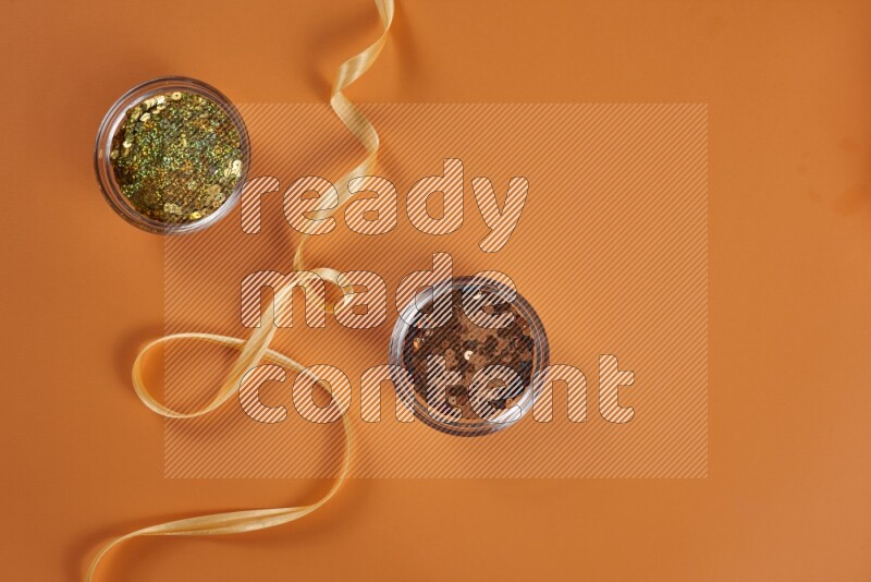 مجموعة من أدوات الخياطة والتفصيل صفراء اللون على خلفية برتقالية