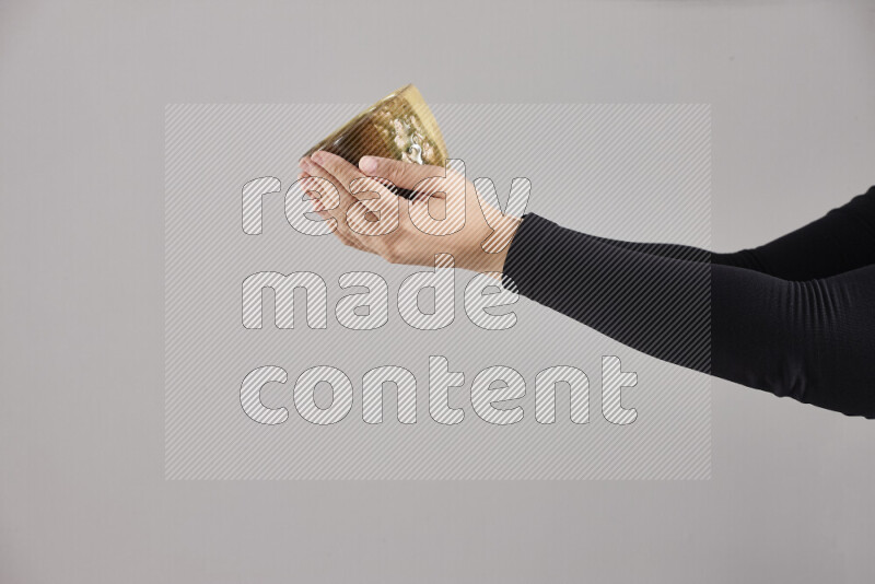 A woman in black abaya holding different pottery essentials in different positions