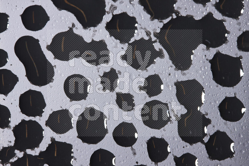 Close-ups of abstract black paint droplets on the surface