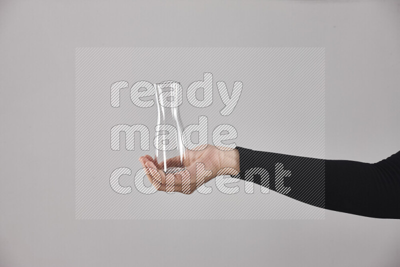 امرأة ترتدي عباءة سوداء تحمل أدوات زجاجية مختلفة في أوضاع متعددة