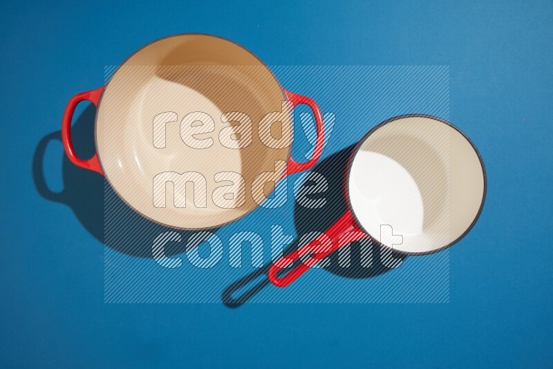 red and white pan and pot on blue background