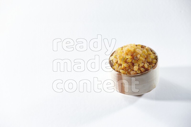 A beige ceramic bowl full of raisins on a white background in different angles