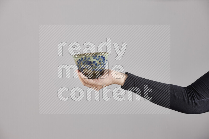 A woman in black abaya holding different pottery essentials in different positions