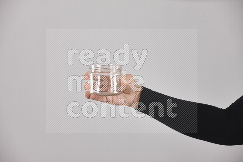 امرأة ترتدي عباءة سوداء تحمل أدوات زجاجية مختلفة في أوضاع متعددة