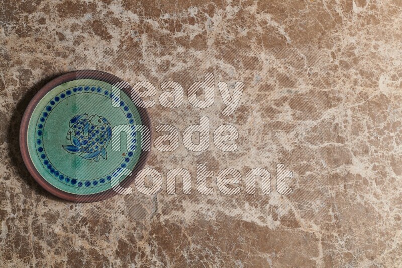 A decorative pottery plate on beige marble background