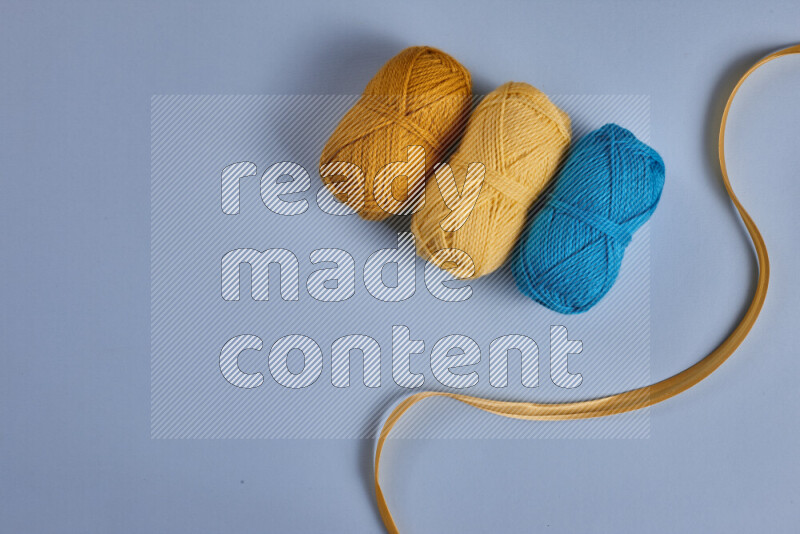 A yellow and blue collection of sewing and tailoring tools arranged on a blue background