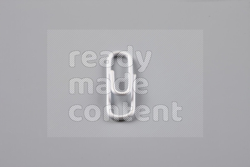 White paper clips isolated on a grey background