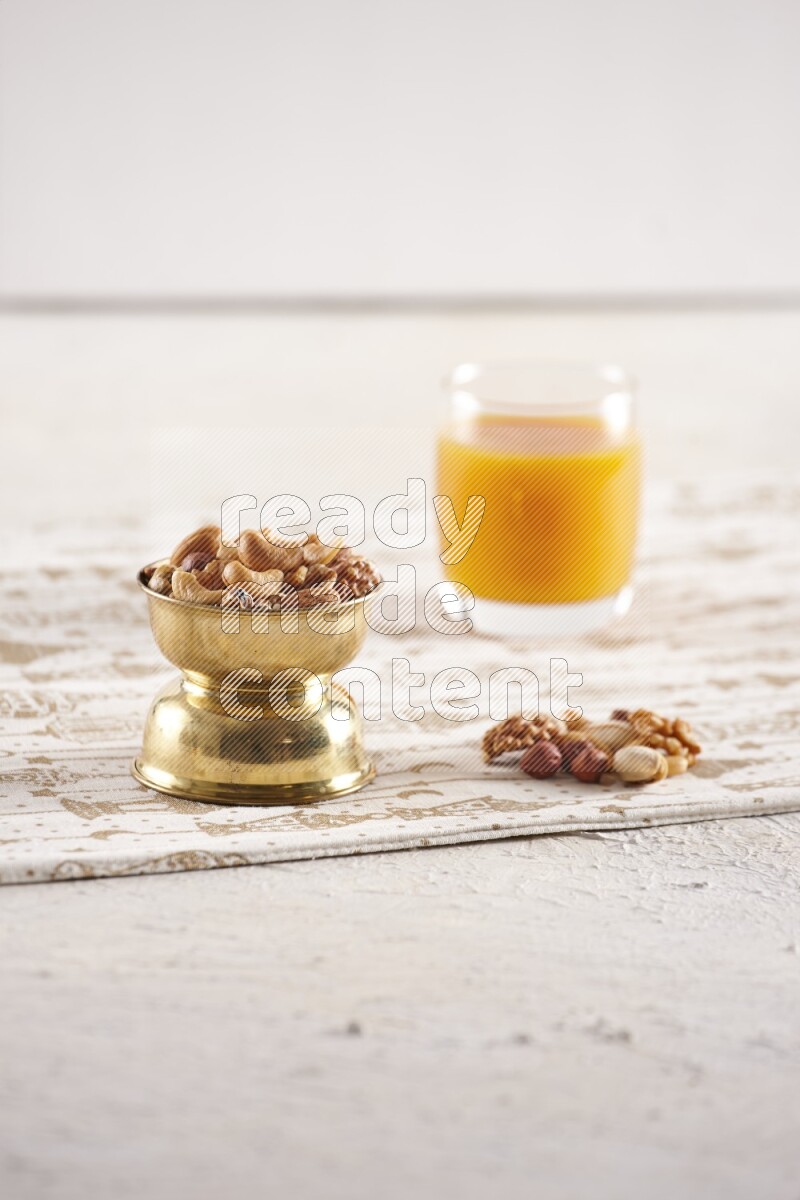 Nuts in a metal bowl with qamar eldin in a light setup
