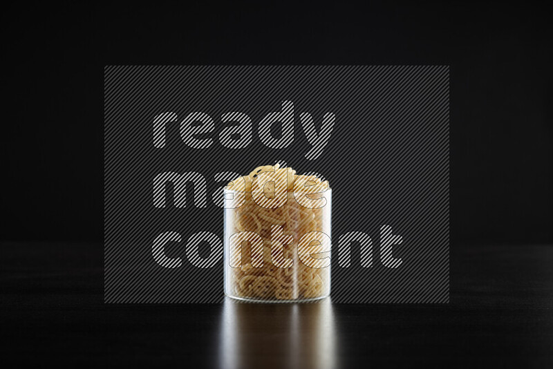 Snacks in a glass jar on black background