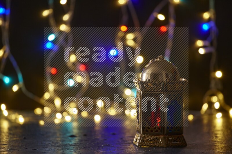 A traditional ramadan lantern surrounded by glowing fairy lights in a dark setup