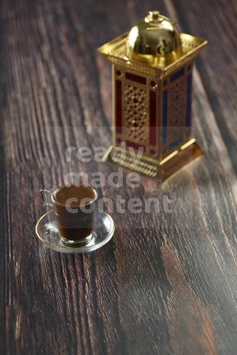 A golden lantern with different drinks, dates, nuts, prayer beads and quran on brown wooden background