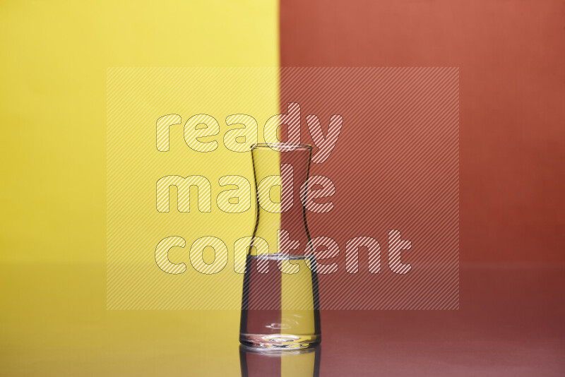 The image features a clear glassware filled with water, set against yellow and dark orange background