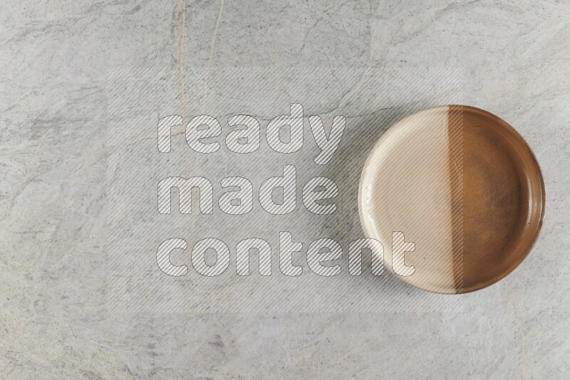 A multicolored pottery oven bowl on grey marble background