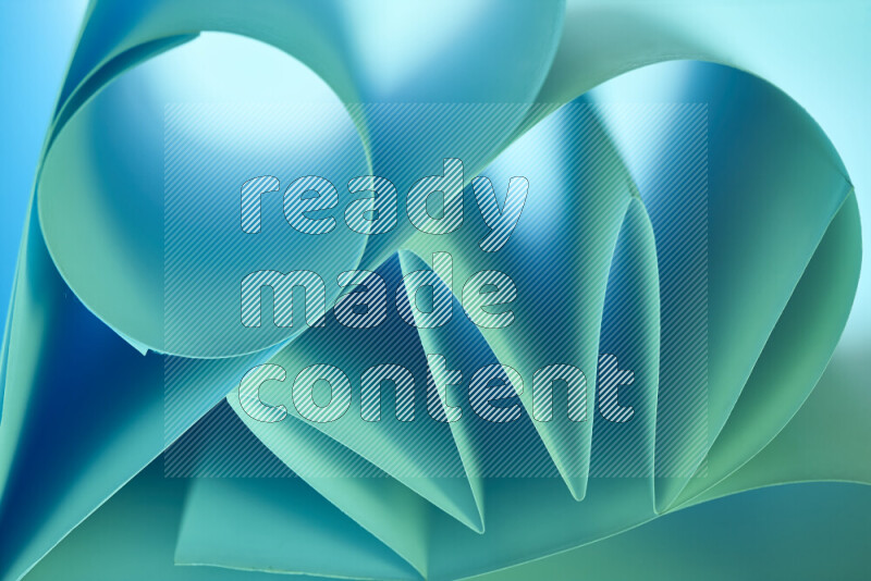 An artistic display of paper folds creating a harmonious blend of geometric shapes, highlighted by soft lighting in green and blue tones
