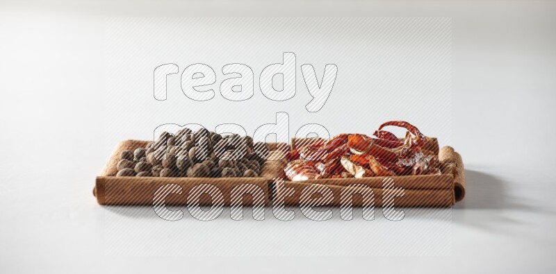 2 squares of cinnamon sticks full of dried red chilis and allspice on white flooring