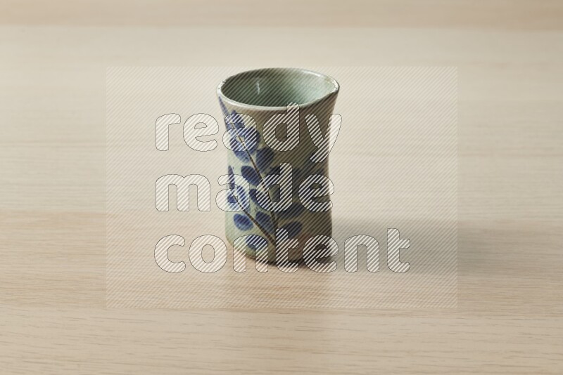A pottery cup on light wooden background