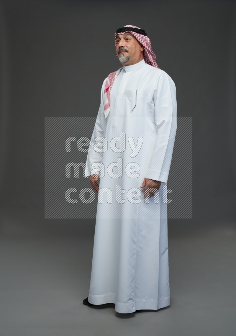 Saudi man with shomag Standing Interacting with the camera on gray background