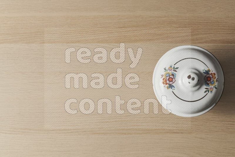 A vintage metal pot on light wooden background