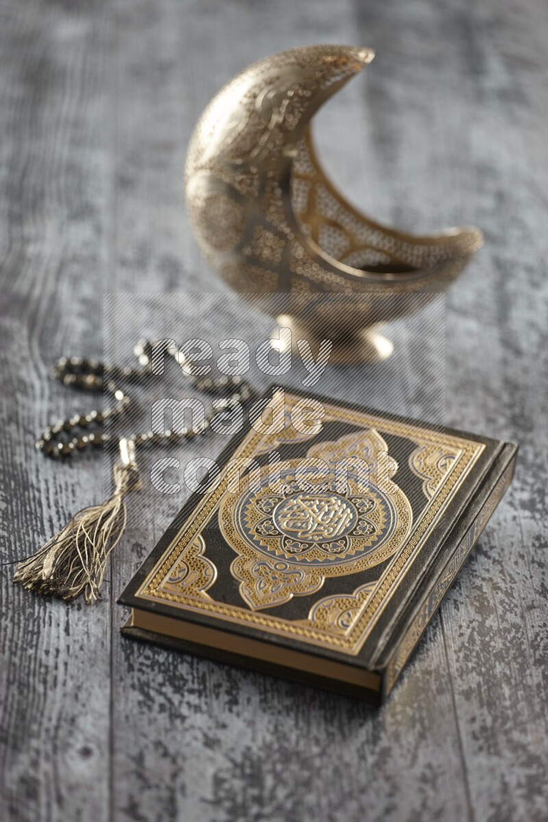 فانوس فضي مع مشروبات مختلفة وتمر ومكسرات وسبحة صلاة وقرآن على خلفية خشبية رمادية