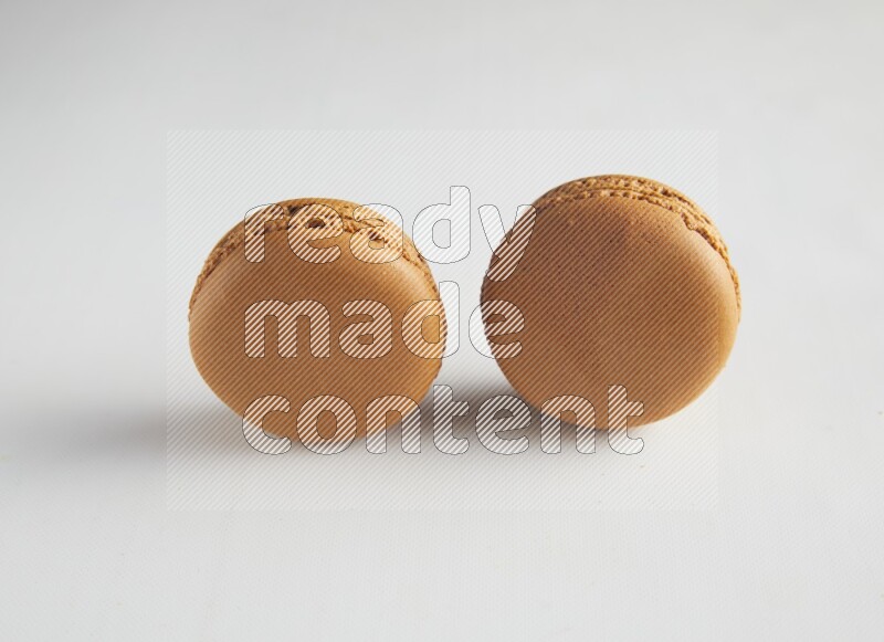 45º Shot of two Brown Maple Taffy macarons on white background