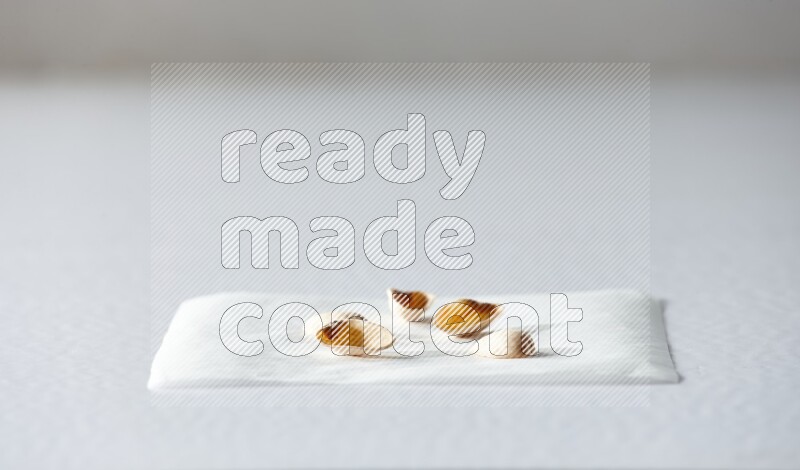 Pistachio peels on a piece of paper on a white background in different angles