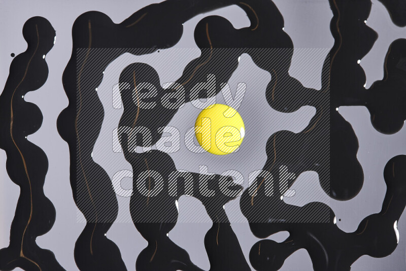 Close-ups of abstract yellow and black paint droplets on the surface