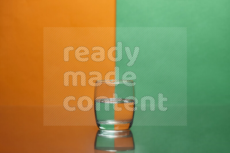 The image features a clear glassware filled with water, set against orange and green background