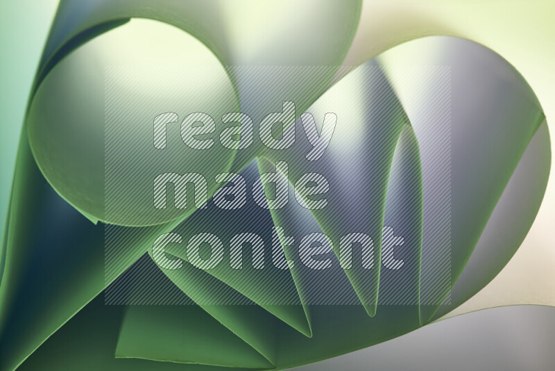 An artistic display of paper folds creating a harmonious blend of geometric shapes, highlighted by soft lighting in green and red tones